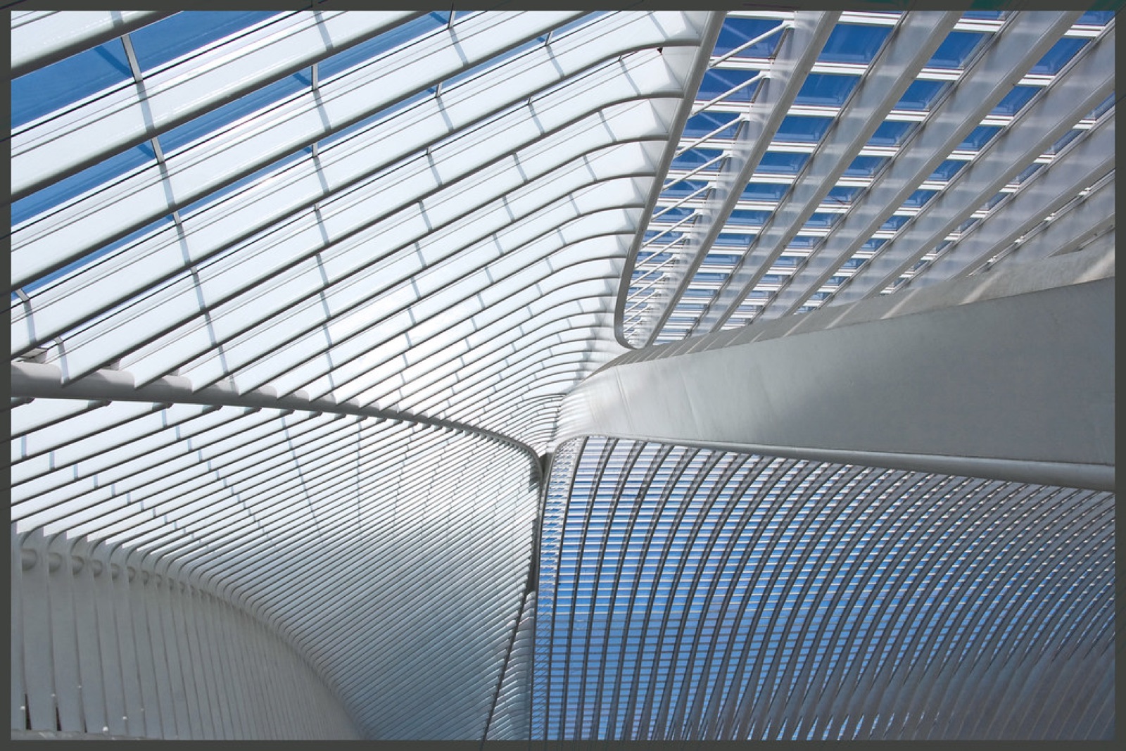 Curved steel and glass roof inside a railway station