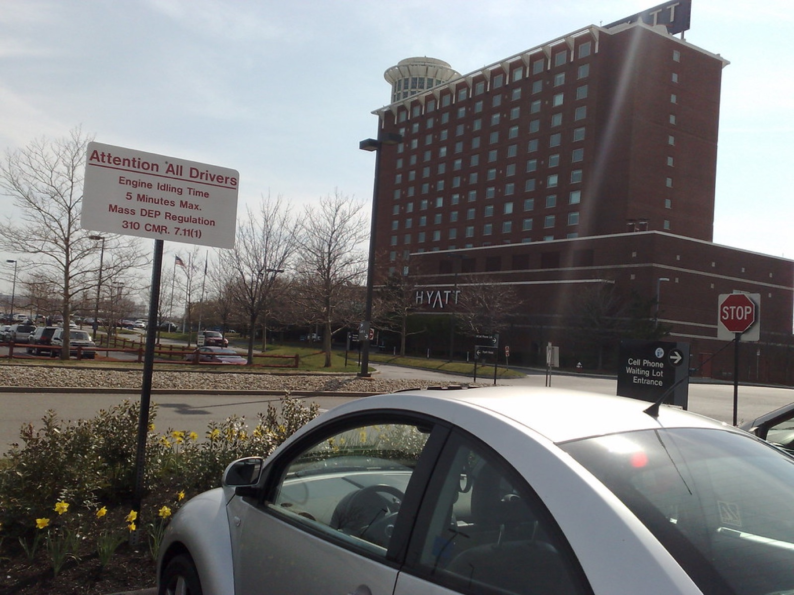 Airport waiting lot with a parked car and nearby building